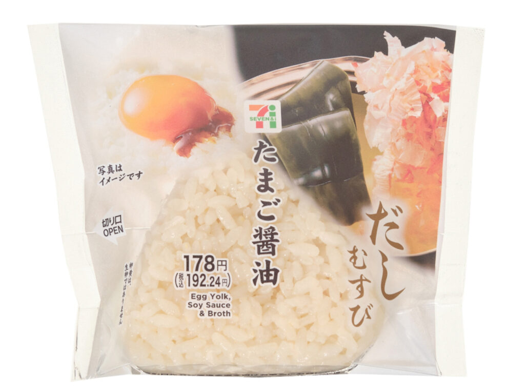 セブンイレブンのだしむすび たまご醤油を比較する。税込価格：192円、カロリー：208kcal、1円あたりカロリー：1.08kcal/円、たんぱく質：4.8g、1円あたりたんぱく質：0.02g/円、脂質：4g、炭水化物：39g、糖質：37.4g、食物繊維：1.6g、食塩相当量：1.8g。濃厚な卵黄ソースと醤油タレを組み合わせた、たまごかけごはん風のおむすびです。アレルギー：卵、小麦。