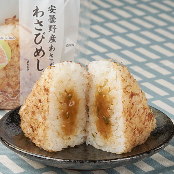 ファミリーマートの【山梨県・長野県】安曇野産わさび わさびめしおむすびを比較する。税込価格：208円、カロリー：186kcal、1円あたりカロリー：0.89kcal/円、たんぱく質：4g、1円あたりたんぱく質：0.02g/円、脂質：1.3g、炭水化物：39.7g、食塩相当量：0.8g。かつお節をまぶしたごはんに、醤油和えした「安曇野産わさび」を中具にしたおむすびです。アレルギー：小麦、卵、大豆。