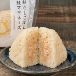 ファミリーマートの鮭だしごはん 鮭マヨネーズおむすび。税込価格：158円、カロリー：194kcal、たんぱく質：3.2g、脂質：3.6g、炭水化物：37.6g、食塩相当量：0.9g。醤油や鮭だしなどを入れて炊いた、炊き込みごはんのおむすびです。中には鮭だしやたまり醤油ベースのタレなどで味付けしたマヨソースが入っています。アレルギー：小麦、卵、さけ、大豆、りんご。