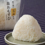 ファミリーマートの塩おむすび。税込価格：150円、カロリー：186kcal、たんぱく質：2.6g、脂質：1.1g、炭水化物：41.7g、食塩相当量：1g。藻塩を表面にふることで、お米のおいしさを味わえるおむすびです。