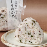 ファミリーマートの【東北】しそわかめおむすび（三陸産わかめ使用）を比較する。税込価格：180円。国産のしそと、細かく刻んだ三陸産わかめを混ぜ込んだ、さっぱりとした酸味と塩味のバランスの良い風味豊かな混ぜご飯おむすびです。
