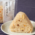 ファミリーマートの【関西】かやくごはんおむすび。税込価格：165円。だしの旨みをきかせた、地域でなじみのあるかやくごはんのおむすびです。