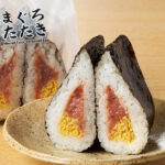 ファミリーマートのサンド寿司 まぐろたたきを比較する。税込価格:375円、カロリー:242kcal、1円あたりカロリー:0.65kcal/円、たんぱく質:6.7g、1円あたりたんぱく質:0.02g/円、脂質:3.5g、炭水化物:46.5g、食塩相当量:2g。人気具材のまぐろたたきと錦糸たまごを組み合わせた、食べごたえのあるワンハンドのお寿司です。アレルギー:小麦、卵、大豆。