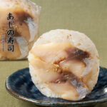 あじの寿司 ファミリーマート ごまを混ぜ込んだ酢飯に、しょうがの風味がきいた醤油ダレとあじのスライスをあわせたワンハンド寿司。