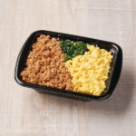 ファミリーマートの鶏のうまみ！鶏そぼろ弁当。税込価格：398円、カロリー：359kcal、たんぱく質：11.3g、脂質：6.3g、炭水化物：65.1g、食塩相当量：1.2g。鶏そぼろ、たまごそぼろ、野沢菜を盛り付けた彩りの良い小容量のお弁当です。アレルギー：小麦、卵、大豆、鶏肉、ゼラチン。