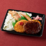 ファミリーマートの肉盛り！コンボ弁当（デミハンバーグ）を比較する。税込価格：645円、カロリー：764kcal、1円あたりカロリー：1.18kcal/円、たんぱく質：20.2g、1円あたりたんぱく質：0.03g/円、脂質：28.9g、炭水化物：107.7g、食塩相当量：3.6g。ハンバーグ、焼ベーコン、ソーセージなど人気の肉系のおかずを盛り付けた、食べごたえ抜群のミックス弁当です。アレルギー：小麦、卵、乳成分、牛肉、ごま、大豆、鶏肉、豚肉、りんご、ゼラチン。