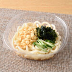 ファミリーマートの【中国・四国】国産小麦の小麦粉使用 三種具材の冷しうどん。税込価格：399円。だしのきいたつゆに、コシと弾力のあるうどんを合わせました。具材として揚げ玉、わかめ、きゅうりをのせたお手頃価格の定番冷しうどんです。