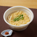 ファミリーマートの【中国・四国】やさしいお出汁 ミニ玉子とじうどん。税込価格：398円。白だし・昆布だしなどで仕立てたやさしい味わいのたまごとじうどんです。