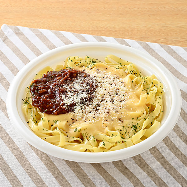 ファミリーマートの生パスタ ミートカルボナーラを比較する。税込価格：550円、カロリー：522kcal、1円あたりカロリー：0.95kcal/円、たんぱく質：20g、1円あたりたんぱく質：0.04g/円、脂質：16.9g、炭水化物：73.7g、食塩相当量：4.1g。チーズ感のあるカルボナーラソースとデミ感のあるミートソースの2種のソースを使用した生パスタです。パルメザン、ブラックペッパー、パセリをトッピングし彩りと味のアクセントをつけました。アレルギー：小麦、卵、乳成分、牛肉、ごま、大豆、鶏肉、豚肉、りんご、ゼラチン。