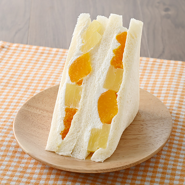 ファミリーマートのフルーツミックスサンドを比較する。税込価格：398円、カロリー：282kcal、1円あたりカロリー：0.71kcal/円、たんぱく質：4.7g、1円あたりたんぱく質：0.01g/円、脂質：14.5g、炭水化物：34.1g、食塩相当量：0.6g。黄桃・みかん・パインの3種のフルーツを使用したサンドイッチです。アレルギー：小麦、乳成分、大豆、もも。