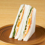 ファミリーマートのサラダチキンとたまごのサンドを比較する。税込価格:398円、カロリー:268kcal、1円あたりカロリー:0.67kcal/円、たんぱく質:19.1g、1円あたりたんぱく質:0.05g/円、脂質:11.6g、炭水化物:22.4g、食塩相当量:1.9g。サラダチキン、ゆでたまご、グリーンリーフ、トマトのソースを組み合わせた、彩り良く満足感のあるサンドイッチです。アレルギー:小麦、卵、乳成分、大豆、鶏肉、りんご、ゼラチン。