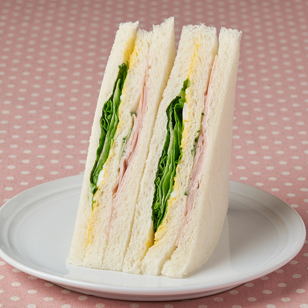 ファミリーマートのハムレタスたまごサンド。税込価格：298円、カロリー：223kcal、たんぱく質：8.7g、脂質：9g、炭水化物：27.6g、食塩相当量：1.4g。ハム、レタス、グリーンリーフ、たまごサラダ、きゅうりの定番具材を組み合わせたサンドイッチです。アレルギー：小麦、卵、乳成分、大豆、鶏肉、豚肉、りんご、ゼラチン。