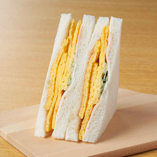ファミリーマートの【東海、北陸、中国・四国】たまご焼きとハムサンドを比較する。税込価格：328円。甘く仕上げたたまご焼き、ハム、きゅうりマヨ和えなどをサンドしました。とんかつソースが味のアクセントです。