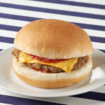 ファミリーマートのチーズバーガーを比較する。税込価格：320円、カロリー：283kcal、1円あたりカロリー：0.88kcal/円、たんぱく質：13g、1円あたりたんぱく質：0.04g/円、脂質：11g、炭水化物：33.8g、食塩相当量：2.4g。バンズにビーフパティ、スライスチーズ、ケチャップ、マスタードを合わせた定番のチーズバーガーです。アレルギー：小麦、卵、乳成分、牛肉、大豆。