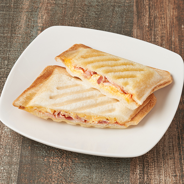 ファミリーマートの【四国】ホットサンド 2個入ベーコンたまご。税込価格：320円。四国限定「ファミマの焼きたてキッチン」の商品です。ベーコンとたまごサラダをサンドして、ケチャップを合わせた2個入のホットサンドです。お店のオーブンで焼き上げて提供します。