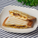 ファミリーマートの【四国】ホットサンド 2個入焼豚たまごを比較する。税込価格：320円。四国地区限定「ファミマの焼きたてキッチン」の商品です。甘みのある醤油ベースのタレに合わせた焼豚を、タマゴサラダといっしょにサンドしたホットサンドです。お店のオーブンで焼き上げて提供します。