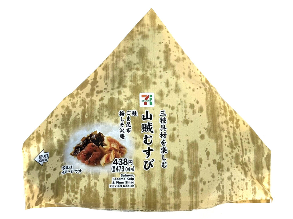 セブンイレブンの山賊むすびを比較する。税込価格：473円、カロリー：371kcal、1円あたりカロリー：0.78kcal/円、たんぱく質：8.3g、1円あたりたんぱく質：0.02g/円、脂質：2.9g、炭水化物：80.3g、糖質：75.6g、食物繊維：4.7g、食塩相当量：3.3g。地区で馴染みのある、鮭・昆布・梅しそ沢庵の３種類の具材を使用した大きなおむすびです。アレルギー：小麦。
