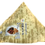 セブンイレブンの山賊むすびを比較する。税込価格：473円、カロリー：371kcal、1円あたりカロリー：0.78kcal/円、たんぱく質：8.3g、1円あたりたんぱく質：0.02g/円、脂質：2.9g、炭水化物：80.3g、糖質：75.6g、食物繊維：4.7g、食塩相当量：3.3g。地区で馴染みのある、鮭・昆布・梅しそ沢庵の３種類の具材を使用した大きなおむすびです。アレルギー：小麦。