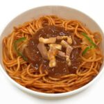 セブンイレブンの太麺ナポリタンを比較する。税込価格：430円、カロリー：438kcal、1円あたりカロリー：1.02kcal/円、たんぱく質：16.4g、1円あたりたんぱく質：0.04g/円、脂質：12.4g、炭水化物：68.3g、糖質：62.3g、食物繊維：6g、食塩相当量：4.8g。ベーコン、玉ねぎ、ピーマンを盛付けた太麺のナポリタンです。アレルギー：卵、乳、小麦。