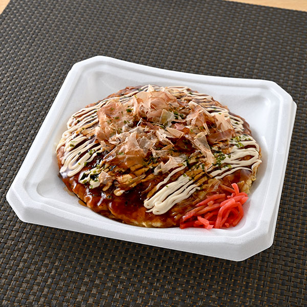 ファミリーマートの鉄板手焼きの豚玉お好み焼。税込価格：598円。かつおだしの風味をきかせたふっくら食感のお好み焼です。ソース、マヨソース、かつお節、紅しょうがなどをトッピングしています。