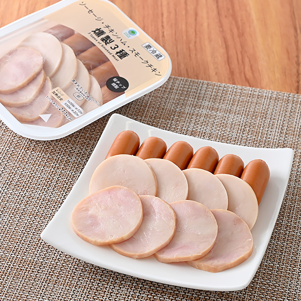 ファミリーマートのソーセージ・チキンハム・スモークチキン燻製3種を比較する。税込価格：398円。桜チップを使用し、燻製させたソーセージ・チキンハム・スモークチキンを盛り合わせた、おつまみにぴったりな商品です。