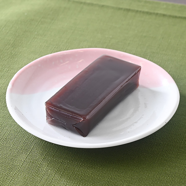 ファミリーマートのミニ羊羹 煉。税込価格：99円。北海道産小豆を使用した、片手で食べられる煉羊羹です。