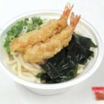 セブンイレブンの海老天わかめうどんを比較する。税込価格：518円、カロリー：421kcal、1円あたりカロリー：0.81kcal/円、たんぱく質：11.9g、1円あたりたんぱく質：0.02g/円、脂質：9g、炭水化物：74.7g、糖質：71.6g、食物繊維：3.1g、食塩相当量：5.2g。定番具材の海老天を盛り付けた温かいうどんです。アレルギー：卵、乳、小麦、えび。