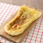 ファミリーマートのどかっと満足パン(バターチキンカレーナン)を比較する。税込価格:248円。もっちり食感のナンにバターチキンカレーを包み、カレーソースを塗って香ばしく焼き上げた、ボリュームのある惣菜パンです。