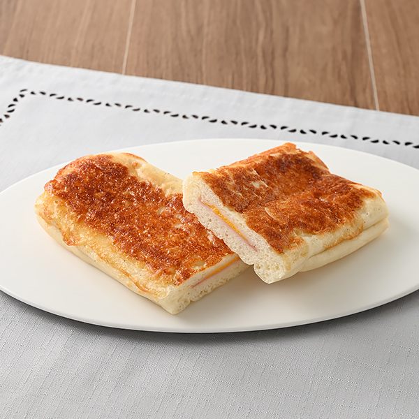 ファミリーマートのハムチーズパニーニを比較する。税込価格：198円。もっちりとした食感のパニーニに、チーズクリーム、ハムを包み、チーズをトッピングして焼き上げた惣菜パンです。