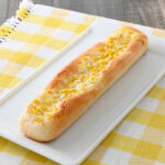 ファミリーマートのコーンマヨスティックを比較する。税込価格：180円。コーンマヨフィリングをトッピングした、スティック形状で食べやすいコーンパンです。