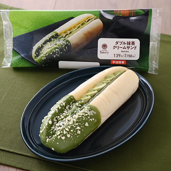 ファミリーマートのダブル抹茶クリームサンド（宇治抹茶）を比較する。税込価格：150円。白生地のロールパンに抹茶ホイップと抹茶クリームを絞り、抹茶チョコと白のビスケットをトッピングしました。