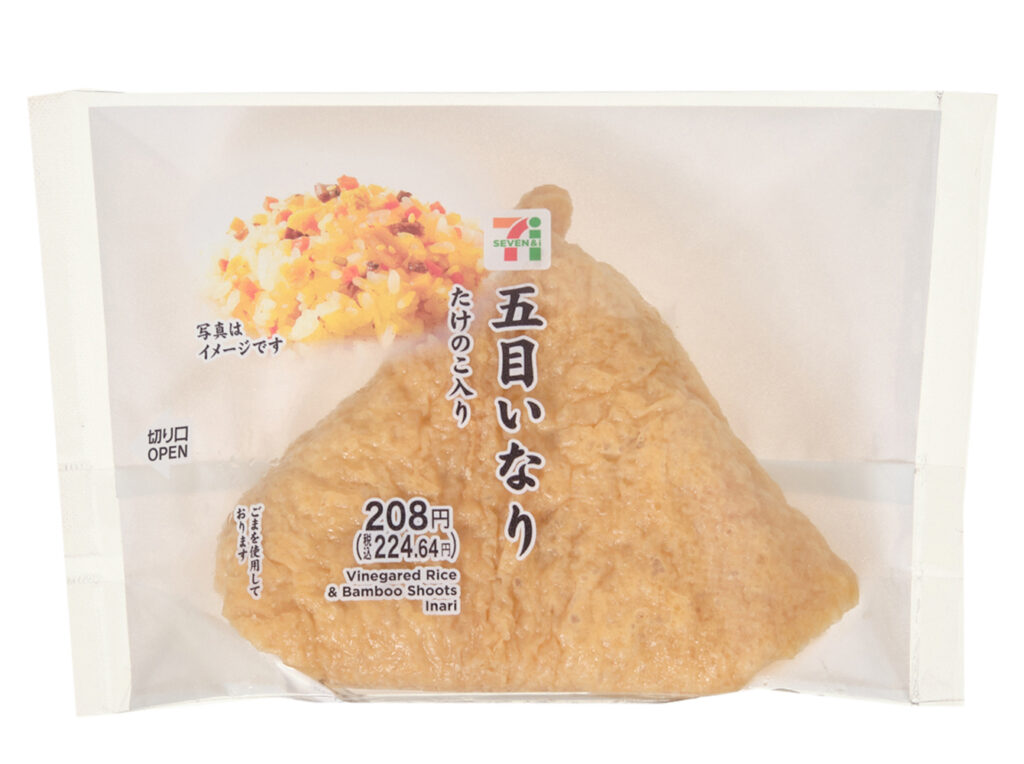 セブンイレブンの五目いなり たけのこ入り。税込価格：225円、カロリー：206kcal、たんぱく質：5.9g、脂質：4g、炭水化物：37.4g、糖質：35.7g、食物繊維：1.7g、食塩相当量：2g。たけのこ，人参，れんこん，椎茸煮，油揚げ，ごぼう，かんぴょうを混ぜ込んだ五目酢飯を、いなり皮で包んだワンハンドタイプのいなり寿司です。アレルギー：小麦。