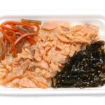 セブンイレブンの道産秋鮭焼ほぐしごはんを比較する。税込価格：464円、カロリー：344kcal、1円あたりカロリー：0.74kcal/円、たんぱく質：11.7g、1円あたりたんぱく質：0.03g/円、脂質：4g、炭水化物：65.9g、糖質：64.5g、食物繊維：1.4g、食塩相当量：2.2g。丁寧にほぐした北海道産の秋鮭と真昆布煮、きんぴらごぼうを盛り付けた御飯です。アレルギー：小麦。