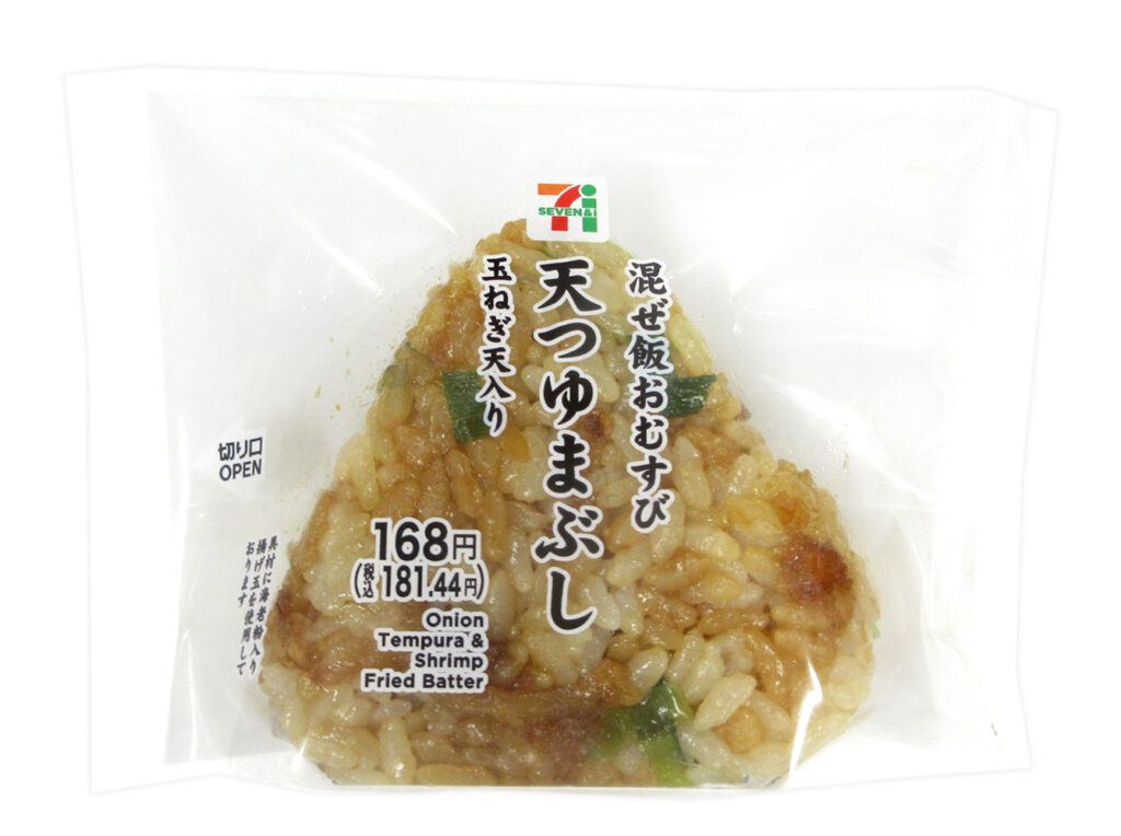 セブンイレブンの天つゆまぶしおむすび（玉ねぎ天入り）を比較する。税込価格：181円、カロリー：206kcal、1円あたりカロリー：1.14kcal/円、たんぱく質：4.2g、1円あたりたんぱく質：0.02g/円、脂質：2.8g、炭水化物：41.9g、糖質：40g、食物繊維：1.9g、食塩相当量：1.7g。だし飯に玉葱の天ぷら、揚玉、海老粉入りの揚玉を混ぜ込み、甘濃い味付けのだし醤油タレをまぶしたおむすびです。アレルギー：卵、小麦、えび。