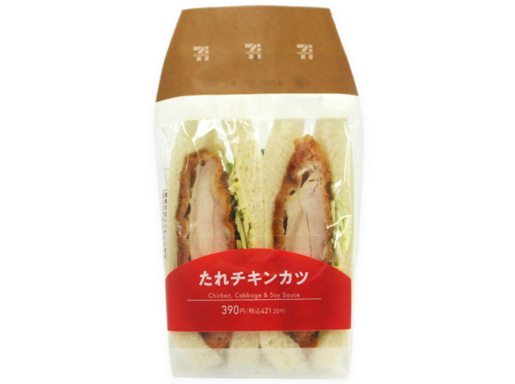 セブンイレブンのたれチキンカツサンドを比較する。税込価格：421円、カロリー：414kcal、1円あたりカロリー：0.98kcal/円、たんぱく質：18.2g、1円あたりたんぱく質：0.04g/円、脂質：20.2g、炭水化物：40.8g、糖質：38.9g、食物繊維：1.9g、食塩相当量：2.1g。甘辛だれで味付けしたチキンカツとキャベツ使用したサンドイッチです。原料高騰により、価格を３８０円（税抜）から３９０円（税抜）に変更させていただきます。アレルギー：卵、乳、小麦。