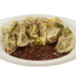 セブンイレブンの１／２日分の野菜 ピリ辛水餃子を比較する。税込価格：430円、カロリー：415kcal、1円あたりカロリー：0.97kcal/円、たんぱく質：13.7g、1円あたりたんぱく質：0.03g/円、脂質：15.8g、炭水化物：57.4g、糖質：51.8g、食物繊維：5.6g、食塩相当量：2.9g。ピリ辛の香味ダレを絡めて野菜と食べる水餃子です。アレルギー：卵、小麦。