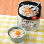 ファミリーマートの4種のチーズで濃厚 カルボごはん。税込価格：498円。卵黄風ソースを絡めて食べるカルボごはんです。バター風味のもち麦入りごはんに、チーズやベーコン、黒コショウをトッピングしました。