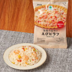 ファミリーマートの海老の旨み！！えびピラフ。税込価格：213円。プリッとした海老の食感が特徴です。旨み広がるブイヨンを使用しました。アメリケーヌソースを使用した海老の風味たっぷりな味わいです。5種類の具材（海老・赤ピーマン・青ピーマン・人参・コーン）が入り、見た目色鮮やかなピラフです。