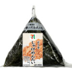 セブンイレブンの手巻おにぎりピリ辛しゃけめんたいを比較する。税込価格：216円、カロリー：171kcal、1円あたりカロリー：0.79kcal/円、たんぱく質：4.2g、1円あたりたんぱく質：0.02g/円、脂質：1.3g、炭水化物：36.5g、糖質：34.6g、食物繊維：1.9g、食塩相当量：1.2g。鮭と明太子を混ぜ合わせた鮭明太フレークを中具に入れた、旨味と辛さのバランスの良いおむすびです。アレルギー：小麦。