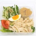 セブンイレブンの蒸し鶏とシャキシャキ野菜サラダを比較する。税込価格：430円、カロリー：214kcal、1円あたりカロリー：0.50kcal/円、たんぱく質：13.8g、1円あたりたんぱく質：0.03g/円、脂質：12.3g、炭水化物：13.6g、糖質：10.3g、食物繊維：3.3g、食塩相当量：3.5g。鶏むね肉の蒸し鶏と、８種類の野菜を使用したシャキシャキ食感の食事サラダ。アレルギー：卵、乳、小麦。