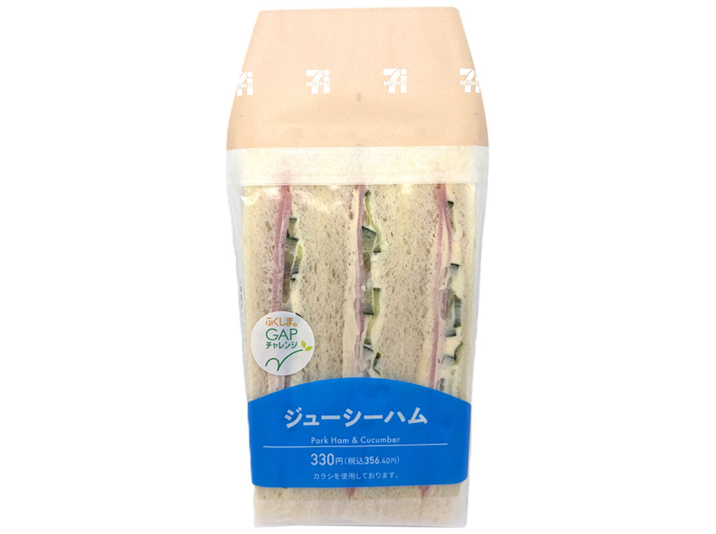 セブンイレブンのジューシーハムサンドを比較する。税込価格：356円、カロリー：354kcal、1円あたりカロリー：0.99kcal/円、たんぱく質：11.9g、1円あたりたんぱく質：0.03g/円、脂質：20.1g、炭水化物：32.2g、糖質：30.5g、食物繊維：1.7g、食塩相当量：1.7g。辛みのあるからしマヨネーズがアクセントのハムと胡瓜サラダを挟みました。アレルギー：卵、乳、小麦。