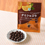 ファミリーマートのやわらかジューシーなグミを味わうグミショコラ オレンジ味グミ×ビターチョコを比較する。税込価格：190円。やわらかくジューシーな味わいのオレンジ味グミにぴったりのビターチョコをコーティングした商品です。