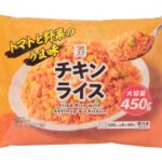 セブンイレブンの７プレミアム チキンライス ４５０ｇを比較する。税込価格：397円、カロリー：159kcal、1円あたりカロリー：0.40kcal/円、たんぱく質：3.2g、1円あたりたんぱく質：0.01g/円、脂質：2.8g、炭水化物：30.6g、糖質：30g、食物繊維：0.6g、食塩相当量：1.2g。トマトケチャップの他にトマトピューレを加え、トマトの旨みを生かした大容量のチキンライスです。アレルギー：小麦。