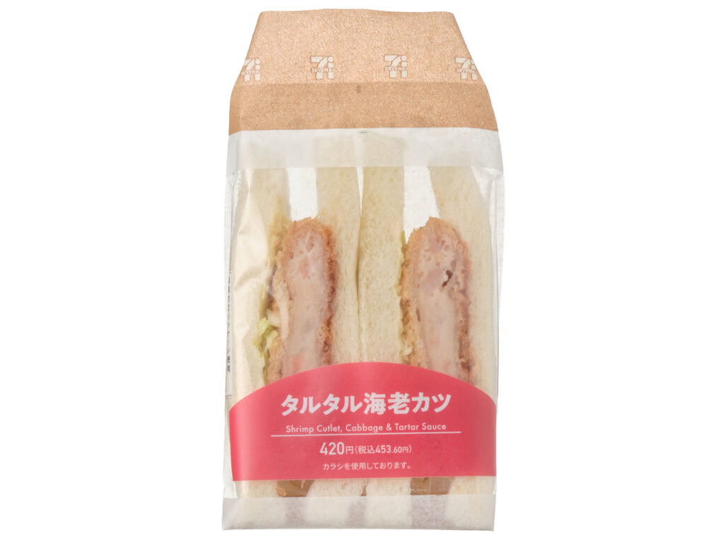 セブンイレブンのタルタル海老カツサンドを比較する。税込価格：454円、カロリー：459kcal、1円あたりカロリー：1.01kcal/円、たんぱく質：12.9g、1円あたりたんぱく質：0.03g/円、脂質：25.2g、炭水化物：46.2g、糖質：44.1g、食物繊維：2.1g、食塩相当量：2.5g。海老の剥き身を使用した食感の感じられる海老カツに、相性の良いタルタルソースとキャベツを組み合わせたサンドイッチです。アレルギー：卵、乳、小麦、えび。