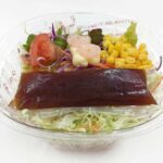 セブンイレブンのくずして食べるパリパリ麺のサラダを比較する。税込価格：419円、カロリー：351kcal、1円あたりカロリー：0.84kcal/円、たんぱく質：6.5g、1円あたりたんぱく質：0.02g/円、脂質：18.7g、炭水化物：41.3g、糖質：37.2g、食物繊維：4.1g、食塩相当量：2.8g。皿うどんの麺と一緒に、１日に必要な野菜の１／３日分が摂れるサラダです。食感も楽しめる満足感のある食事サラダです。アレルギー：卵、乳、小麦、えび。