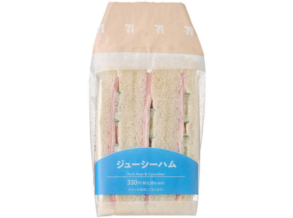 セブンイレブンのジューシーハムサンドを比較する。税込価格：356円、カロリー：355kcal、1円あたりカロリー：1.00kcal/円、たんぱく質：12.2g、1円あたりたんぱく質：0.03g/円、脂質：20.5g、炭水化物：31.2g、糖質：29.6g、食物繊維：1.6g、食塩相当量：1.8g。辛みのあるからしマヨネーズがアクセントのハムと胡瓜サラダを挟んだサンドイッチです。アレルギー：卵、乳、小麦。