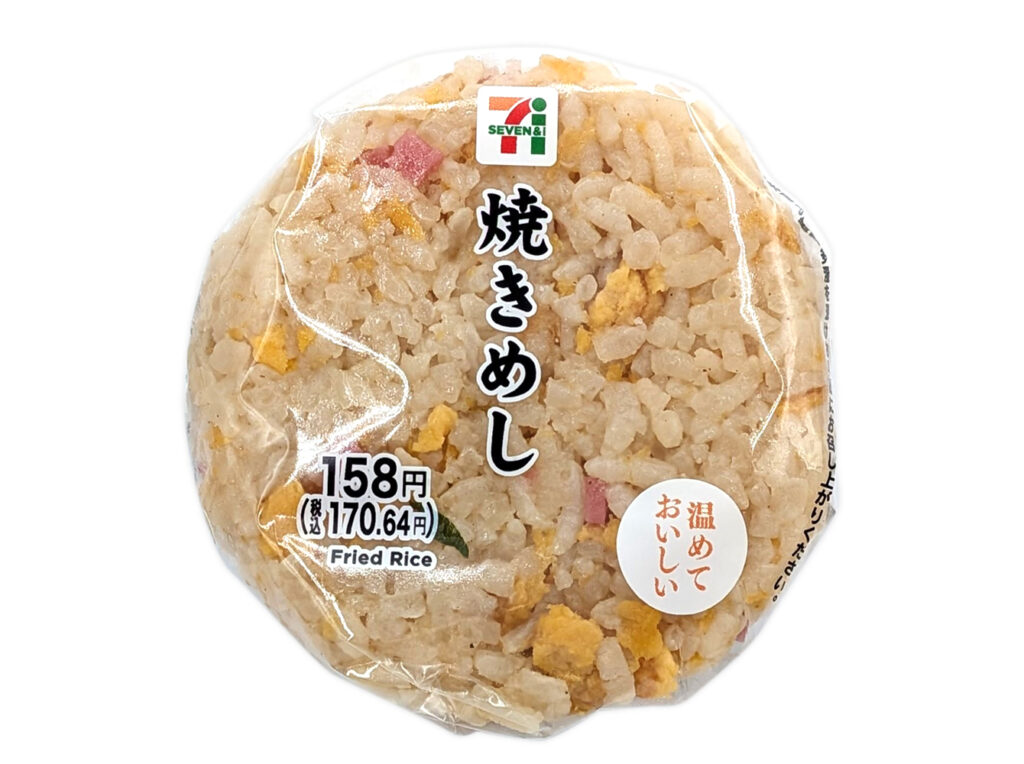 セブンイレブンの焼きめしおむすびを比較する。税込価格：171円、カロリー：217kcal、1円あたりカロリー：1.27kcal/円、たんぱく質：5.9g、1円あたりたんぱく質：0.03g/円、脂質：8.1g、炭水化物：30.8g、糖質：29.5g、食物繊維：1.3g、食塩相当量：1.9g。ラーメンのたれで味付けをした香ばしい炒飯のおむすびです。アレルギー：卵、乳、小麦。