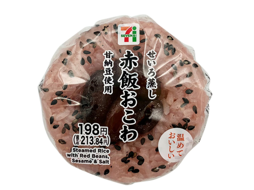 セブンイレブンのせいろ蒸し 赤飯おこわおむすび（甘納豆使用）を比較する。税込価格：214円、カロリー：237kcal、1円あたりカロリー：1.11kcal/円、たんぱく質：4.5g、1円あたりたんぱく質：0.02g/円、脂質：1.5g、炭水化物：52g、糖質：50.8g、食物繊維：1.2g、食塩相当量：0.6g。せいろで蒸したもちもち食感の赤飯おこわに、地区で馴染みのある甘納豆を乗せたおむすびです。アレルギー：なし。