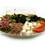 セブンイレブンの北海道名物ラーメンサラダ ねばねばオクラとネバリスターを比較する。税込価格：397円、カロリー：370kcal、1円あたりカロリー：0.93kcal/円、たんぱく質：11.4g、1円あたりたんぱく質：0.03g/円、脂質：9.3g、炭水化物：61.5g、糖質：58.8g、食物繊維：2.7g、食塩相当量：3.3g。北海道池田町産の山芋「ネバリスター」とオクラやツナ、わかめの具材にキャベツや大根などの野菜を組み合わせた、ピリ辛の中華ドレッシングで食べるラーメンサラダです。アレルギー：卵、小麦。