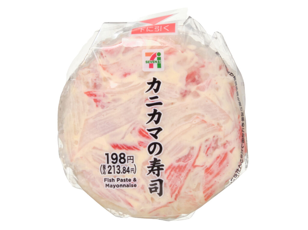 セブンイレブンのカニカマの寿司。税込価格：214円、カロリー：264kcal、たんぱく質：6g、脂質：10.7g、炭水化物：36.6g、糖質：35.4g、食物繊維：1.2g、食塩相当量：2.2g。マヨネーズと和えたカニ風味のかまぼこを使用した、手軽に食べられるワンハンドタイプの寿司です。アレルギー：卵、小麦、かに。